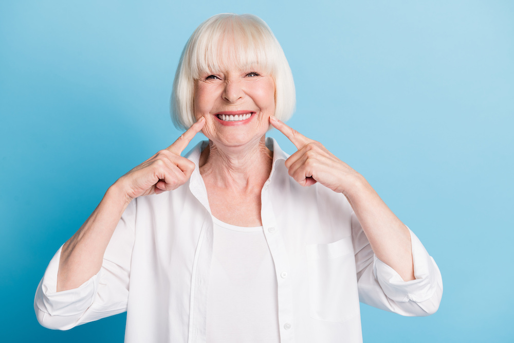 woman pointing to her new teeth