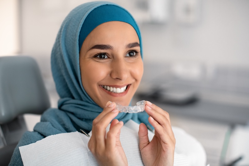 lady holding Invisalign aligners