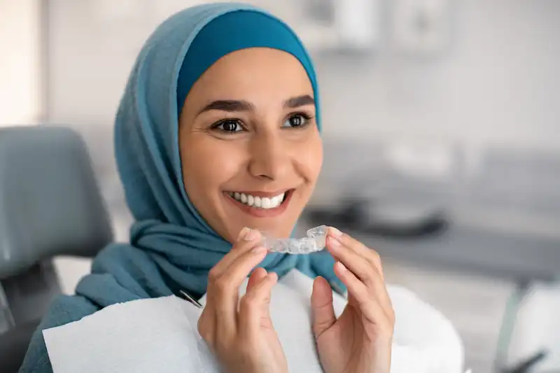 lady holding Invisalign aligners