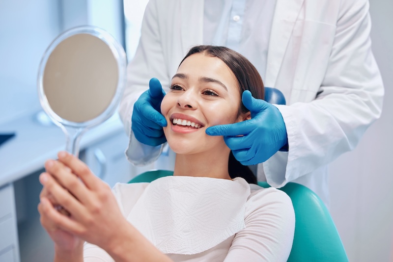 person looking at mirror on her new smile