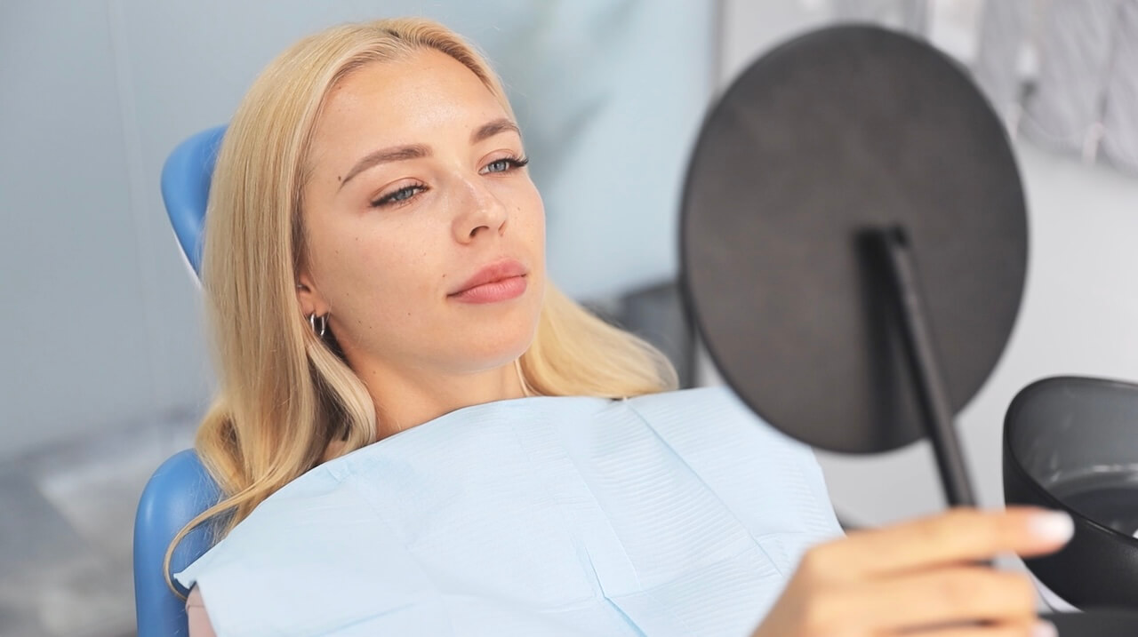 Lady looking at a mirror with a new smile